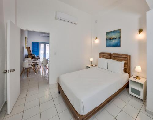 a white bedroom with a bed and a dining room at Casa Pelayo in San Juan