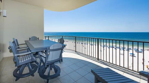 a balcony with a table and chairs and the ocean at Phoenix West 603 in Orange Beach