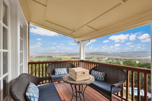 a balcony with wicker chairs and a table and a view at Whispering Ridge Ranch in Wimberley
