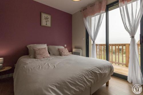 a bedroom with a bed and a large window at Les bichous in Saint-Thomas