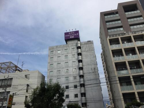 a building with a purple sign on top of it at Hotel Crown Hills Kofu in Kofu