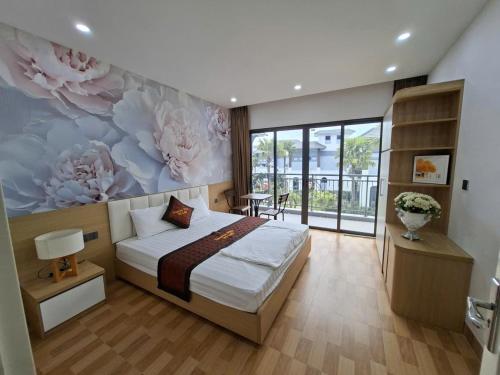 a bedroom with a bed with a flower mural on the wall at V3L05-Sonasea Vân Đồn in Thâm Câu