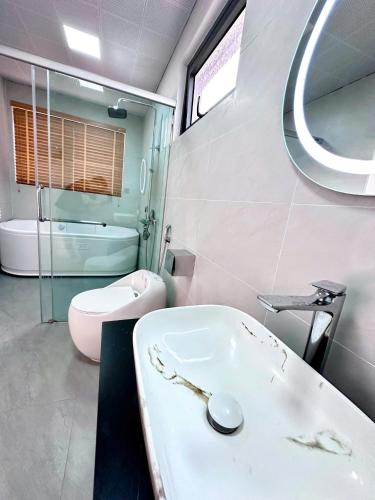 a bathroom with a sink and a toilet and a mirror at V3L05-Sonasea Vân Đồn in Thâm Câu