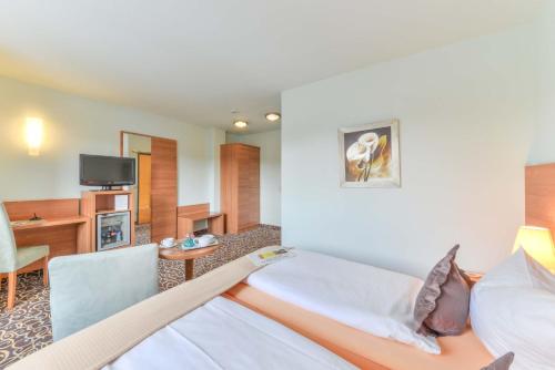 a hotel room with two beds and a tv at ateckhotel Kirchheim/Teck in Kirchheim unter Teck