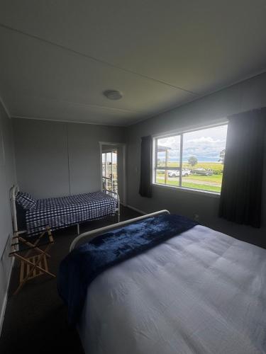 a bedroom with a large bed and a window at Seaview Cabin in Tapu