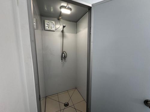 a shower with a glass door in a bathroom at Seaview Cabin in Tapu