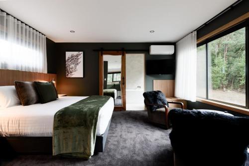 a bedroom with a bed and a chair at Moss Wood Lane: Peaceful Bath Hideaway in Spreyton