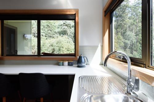 a kitchen with a sink and a window at Moss Wood Lane: Peaceful Bath Hideaway in Spreyton