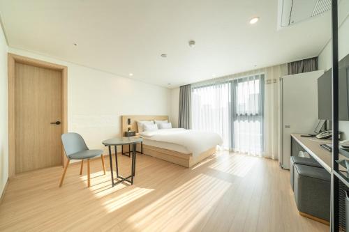 ein Schlafzimmer mit einem Bett, einem Tisch und einem Stuhl in der Unterkunft hotel J bay in Samgong-ni