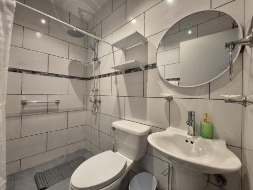 a white bathroom with a toilet and a sink at Villa Sirena Azul Apt 2 in Palm-Eagle Beach