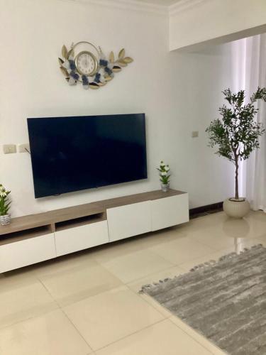 a living room with a flat screen tv on a wall at Compound Porto New Cairo in Cairo