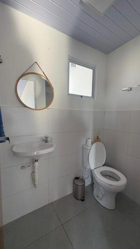 a bathroom with a toilet and a sink and a mirror at Maramarbh43 in Luis Correia