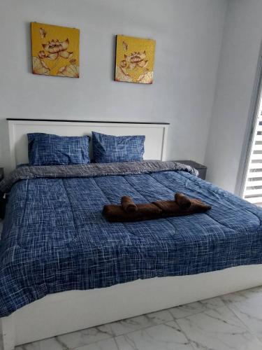 a brown teddy bear laying on top of a bed at Eid and Philippe's Home building A9 in Ban Ko Kwang