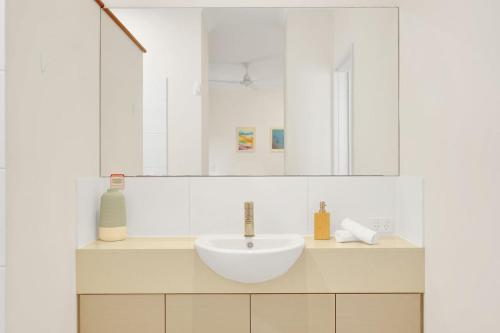 a white bathroom with a sink and a mirror at Balu luxe in Broome