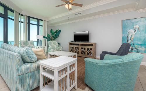 a living room with a couch and chairs and a tv at Phoenix West 708 in Orange Beach