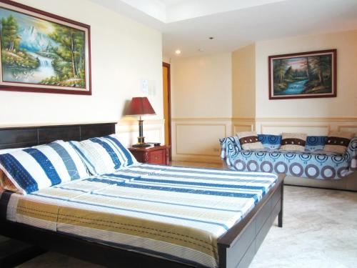 ein Schlafzimmer mit einem großen Bett und blauen und weißen Kissen in der Unterkunft Baywatch Tower in Manila