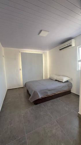 a bedroom with a bed in a white room at Maramarbh43 in Luis Correia