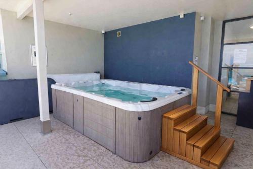 a jacuzzi tub in a room with a staircase at Sky Tower Studio - Pools, Spa, Gym & Super King in Auckland