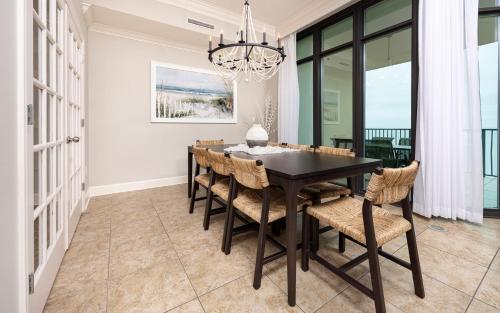 a dining room with a black table and chairs at Phoenix West 2008 in Orange Beach