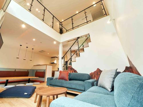 a living room with two blue couches and a table at Rakuten STAY VILLA Hakone Sengokuhara South Wing 102 BBQ Terrace capacity of 10 persons in Hakone