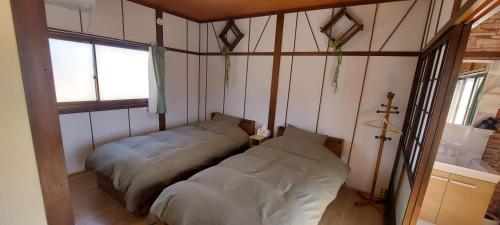 a room with two beds in it with a window at Suzume no oyado SO1 in Shima