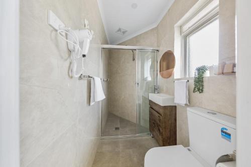 a bathroom with a shower and a toilet at Rainbow Motel Queanbeyan in Queanbeyan