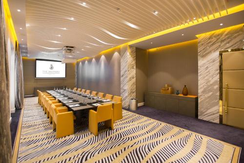 a conference room with a long table and yellow chairs at The Biltmore Tbilisi Hotel in Tbilisi City