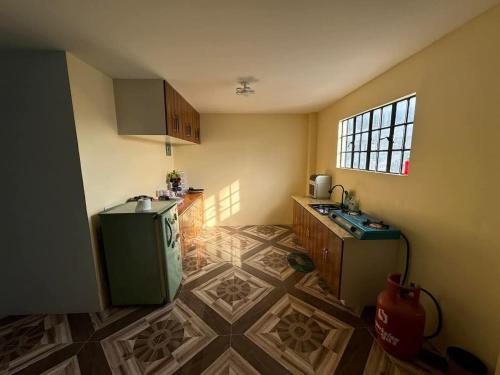 a kitchen with a refrigerator and a sink in a room at Rjoyz transient house in Itogon