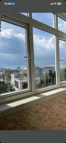 a room with three windows with a view of a city at King hotel in Dĩ An