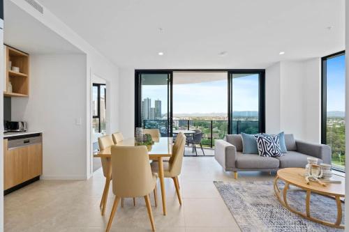 a kitchen and living room with a table and chairs at The Gallery Broadbeach - Hosted by Gold Coast Luxury Resorts in Gold Coast