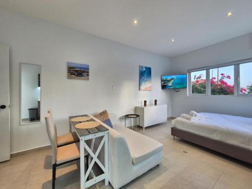 a bedroom with a bed and a table and a desk at Villa Sirena Azul Apt 1 in Palm-Eagle Beach