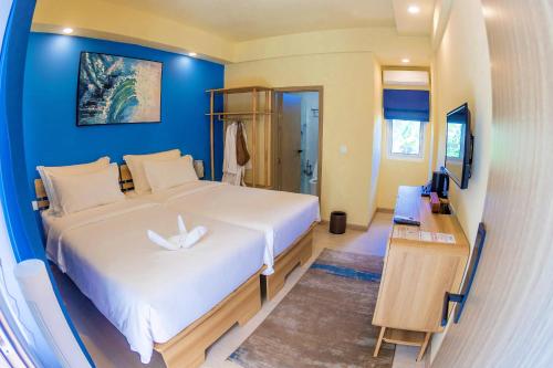 a bedroom with a white bed and a blue wall at Cher resort Maldives in Kamadhoo
