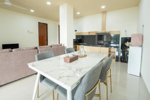 a kitchen and dining room with a white table and chairs at Green Hill Service Apartment in Labuan Bajo