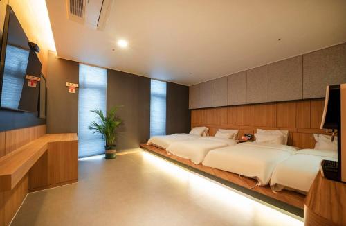 ein Schlafzimmer mit zwei Betten in einem Zimmer in der Unterkunft Naju Holius Hotel in Naju