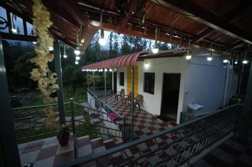 a balcony of a house with chairs and a porch at Malnad Mist in Attigundi