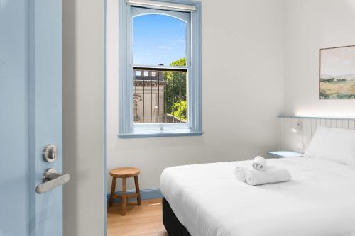 a bedroom with a bed and a window at The Surrey 6 in Sydney