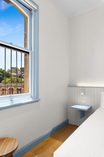 a bedroom with a bed and a window at The Surrey 6 in Sydney