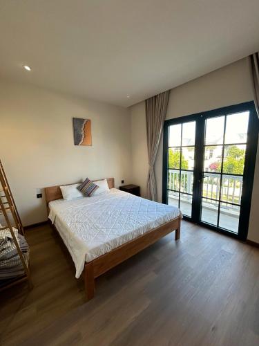 a bedroom with a bed and a large sliding glass door at ACIS SmartHome NovaWorld in Bình Tú