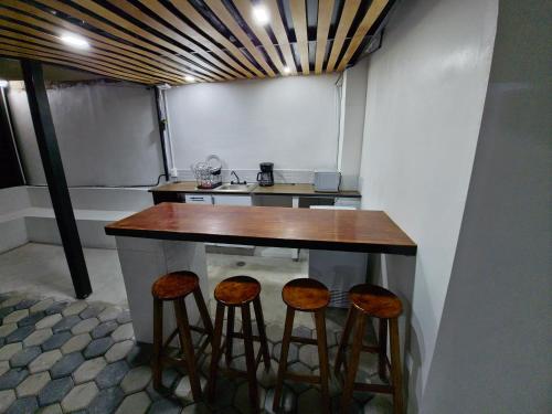 a kitchen with a counter with stools around it at Casa Rayon Oaxaca in Oaxaca City