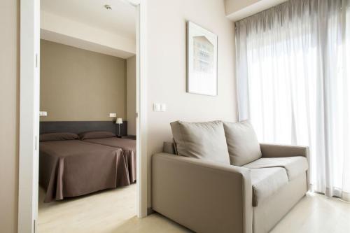 a bedroom with a bed and a chair and a mirror at Residencia Universitaria Damia Bonet in Valencia