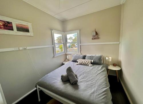 a small bedroom with a bed with two pillows at Barefoot and Beach Bound by Book Jervis Bay in Vincentia