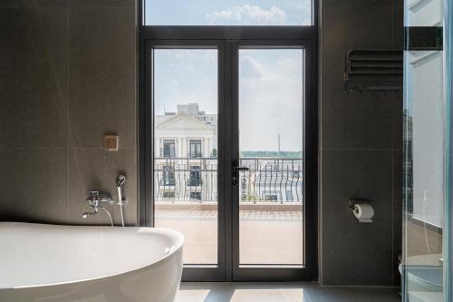 a bathroom with a tub and a large window at AviCasa T21 in Gò Công