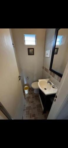 a bathroom with a sink and a toilet and a mirror at CHALET económico cerca del Mar in Costa Azul