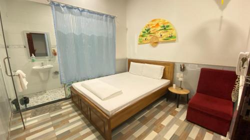 a small bedroom with a bed and a bathroom at Nhật Minh Hotel in Thuan An