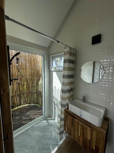 a bathroom with a sink and a window at Beachfront Tiny House - Eden Pod with FREE Rowboat in Nathon Bay