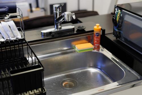 a kitchen sink with a dish drying rack next to it at Gran Form Kita 12-jo in Kita-sanjō