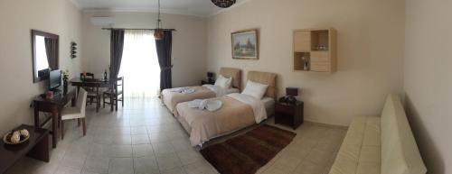 a bedroom with a bed and a dining room with a table at Kalloni Royal Resort in Kalloni