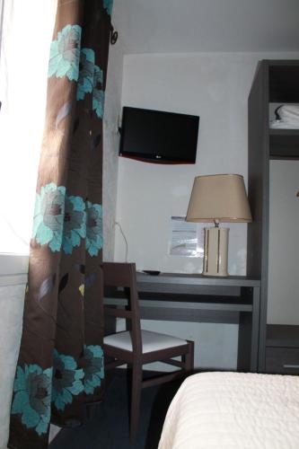 a bedroom with a bed and a desk with a chair at Don Quichotte in Vallet