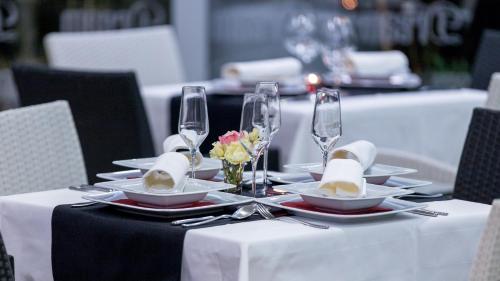 a table with plates and wine glasses on it at Dream Hotel in Velika Gorica