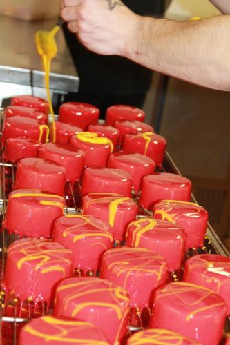 a bunch of red and yellow cupcakes on a rack at Don Quichotte in Vallet